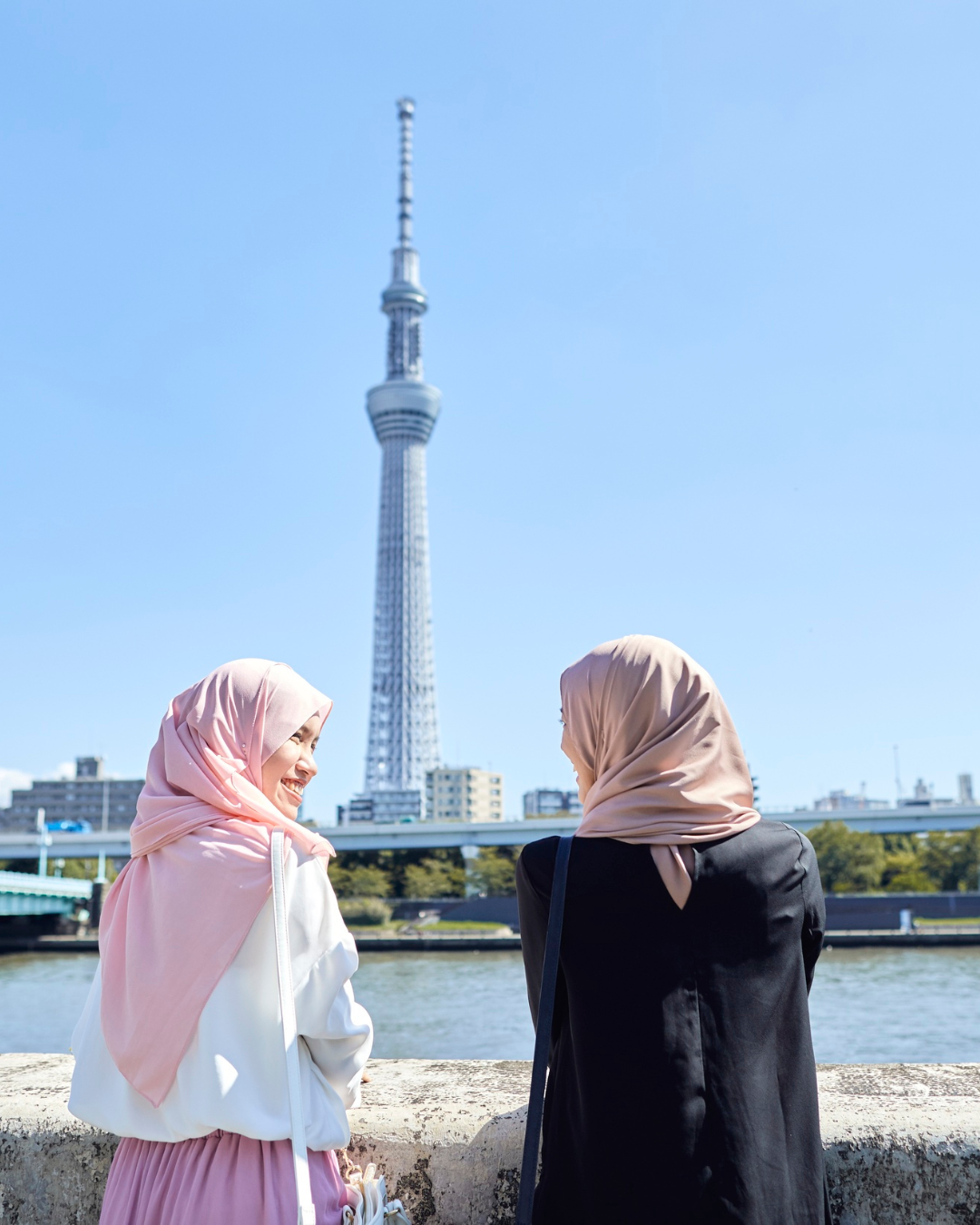 Two travelers enjoying the riverside view of Tokyo Skytree